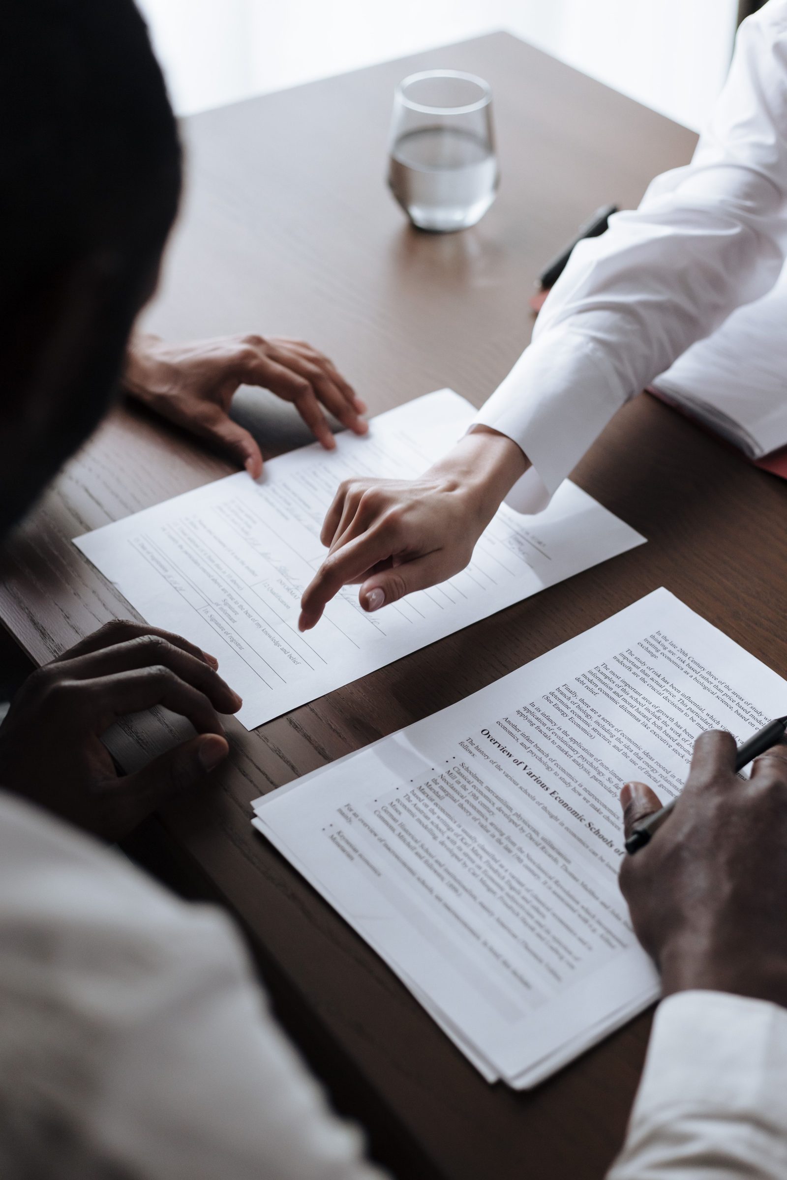 Two people reviewing papers across a table.
